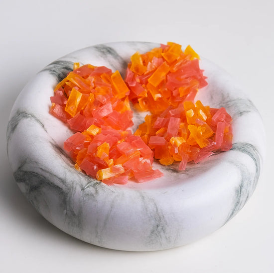 Orange and pink crystal candy clusters on white background; strawberry + orange thin-cut clusters with jewel-like shine.