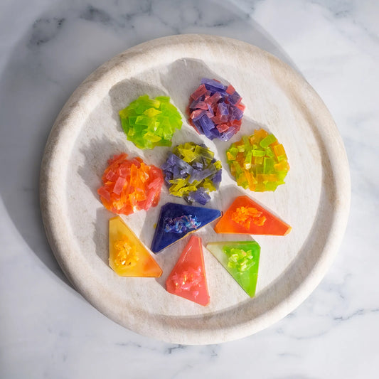 Overhead of five Japanese crystal candy clusters and five crystal candy clusters on a round marble table; thin-slice clusters with satisfying ASMR crunch.