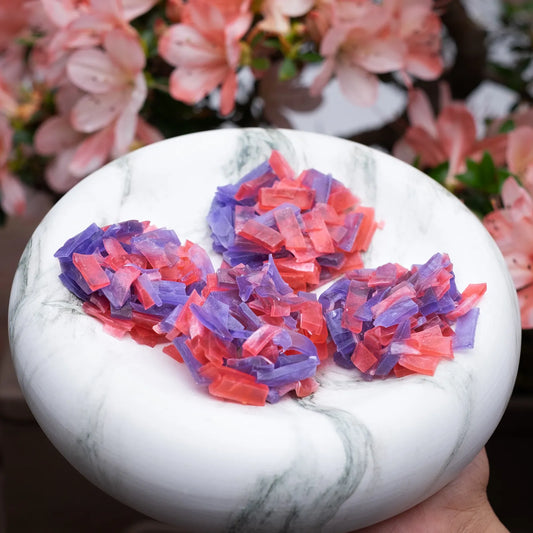 Red and purple crystal candy clusters on a marble plate; strawberry + blueberry flavour; thin-cut for satisfying crunch