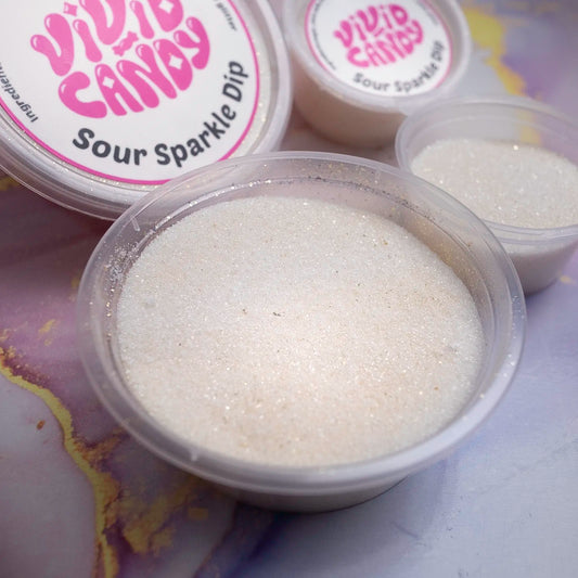 Close view of an open tub showing the glittery sour sugar texture of Sour Sparkle Dip; branded lids in the background.
