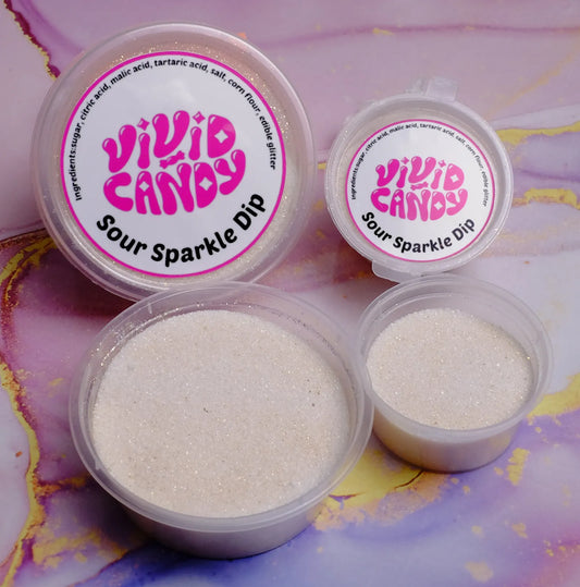 Open and lidded tubs of Sour Sparkle Dip—sparkling sour sugar for crystal candy—on a pastel marble background.
