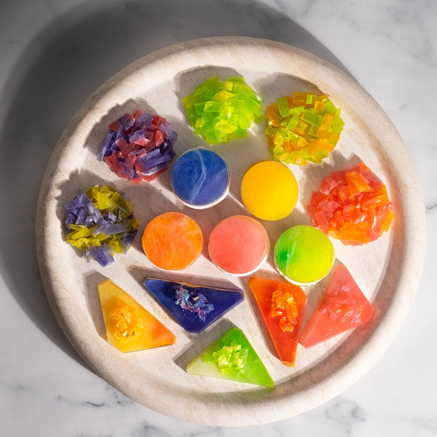 Overhead photo of the Ultimate Crystal Candy Bundle on a round marble plate—colourful Japanese crystal candy rounds (with marshmallow) , triangular slices with shard toppers, and thin-slice clusters arranged in a rainbow.