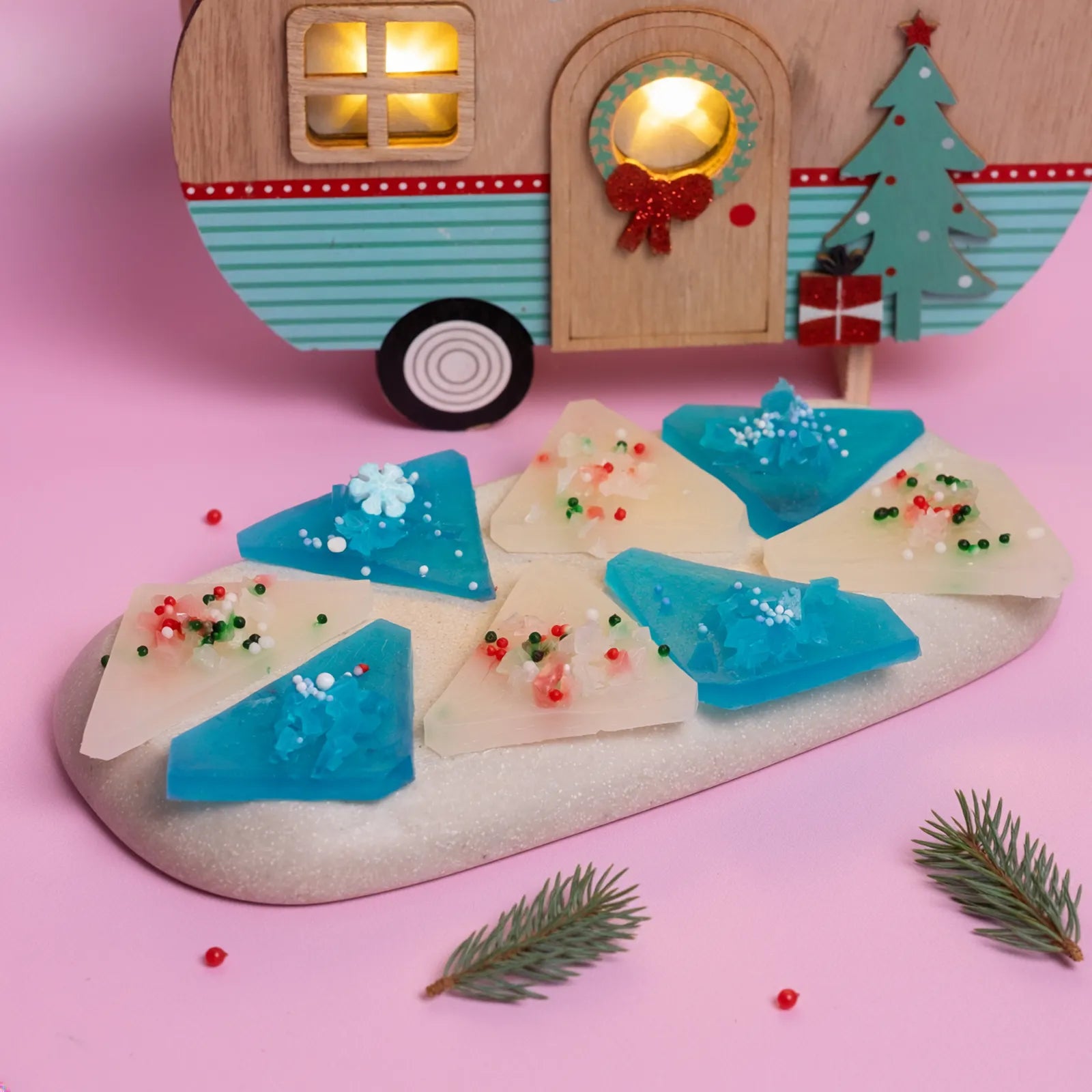 Blue and white Japanese style crystal candy on pink background with a Christmas toy caravan.