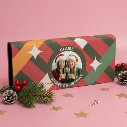 Personalized Christmas gift box with festive design and photo of two people wearing Santa hats.