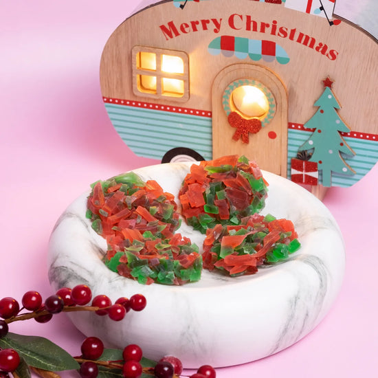 Red and green crystal candy clusters on a pink background with a Christmas-themed wooden sign.